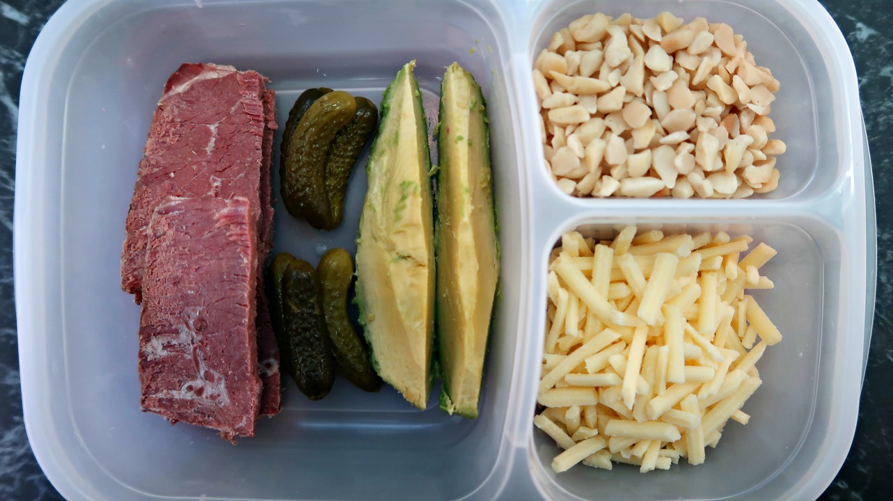 Keto packed lunch box of silverside, pickles, avocado, cheese and nuts