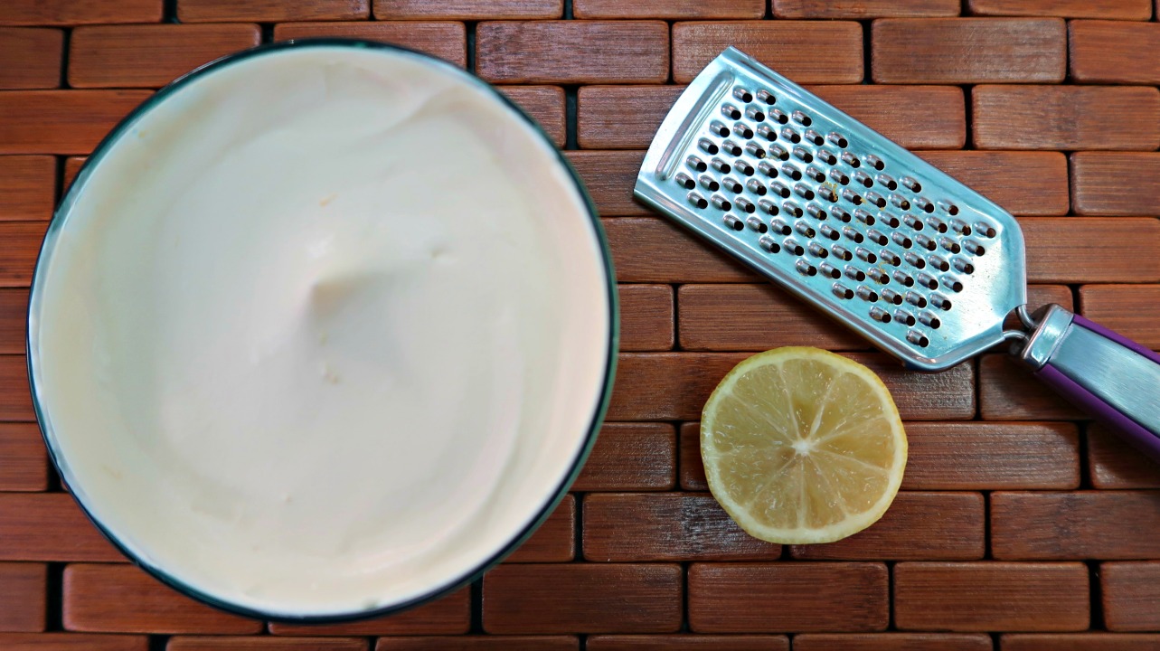 Bowl of Low Carb Lemon Mousse with a lemon and microplane grater on the side