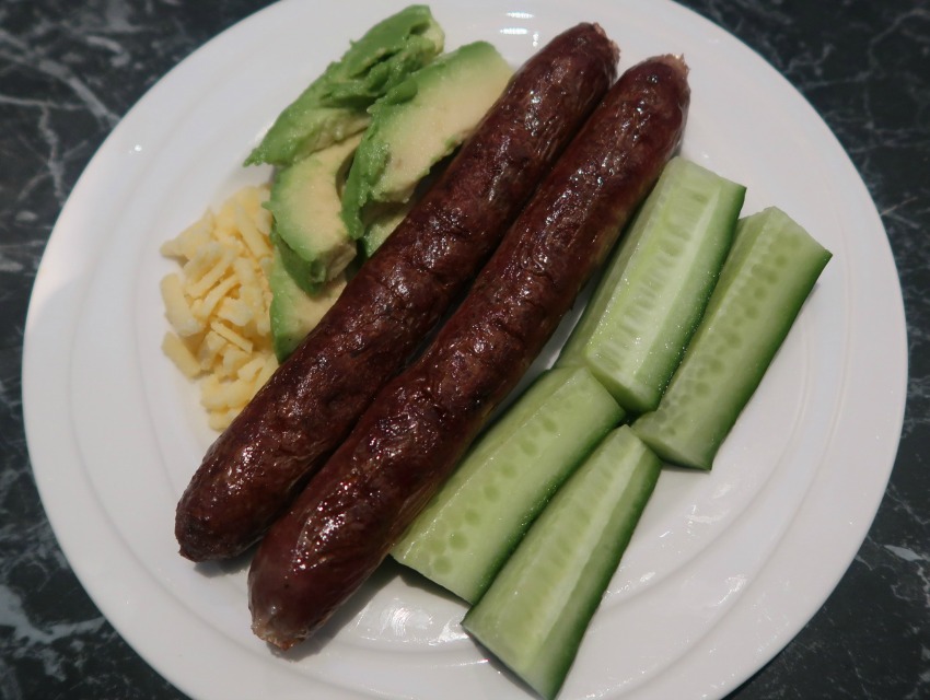 Plate with sausages, cheese, avocado and cucumber