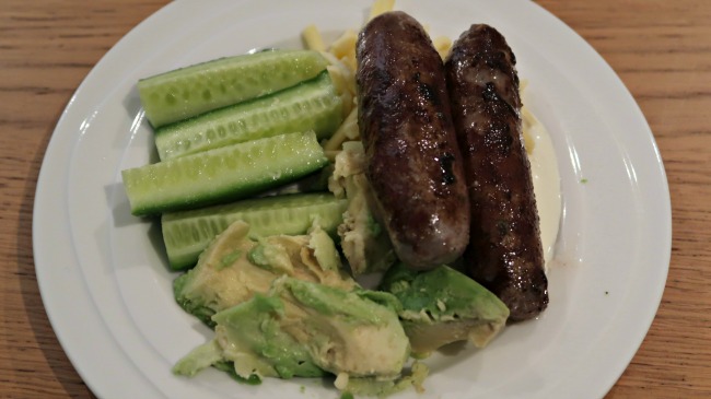 Keto diet plan dinner of sausages, avocado, cucumber and cheese