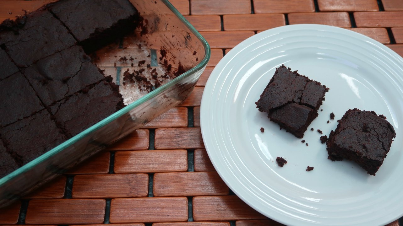 2 Low Carb Chocolate Pumpkin Brownies on a plate besides the dish of brownies