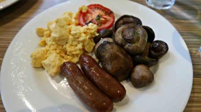 Low Carb Hotel Breakfast Plate with scrambled eggs, sausages, mushrooms and tomato