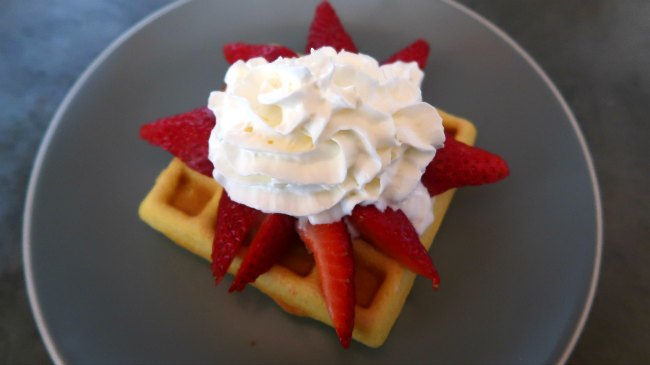 Keto Waffles with coconut flour topped with strawberries and whipped cream