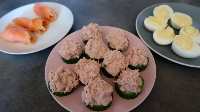 3 Keto Appetizer Recipes on plates - smoked salmon roll ups, tuna and cucumber bites and deviled eggs