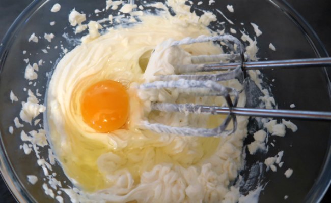 Whisking eggs into cheesecake batter