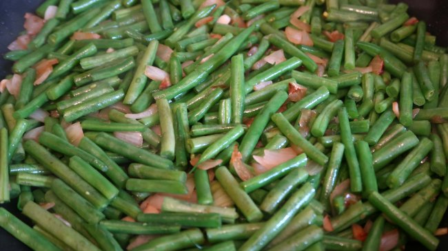 Frying green beans, onion and garlic