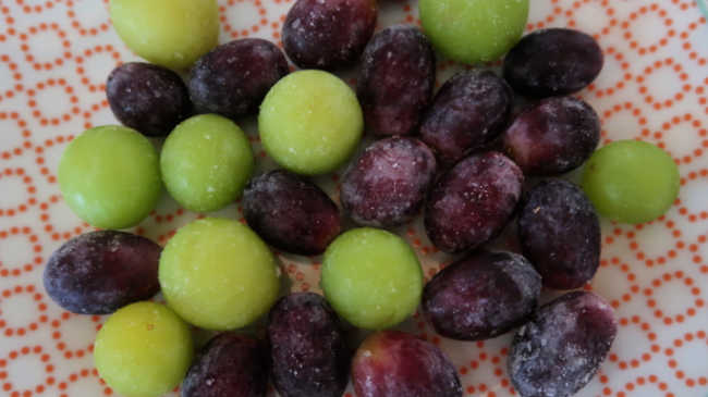 Plate full of frozen fruit - red and green grapes