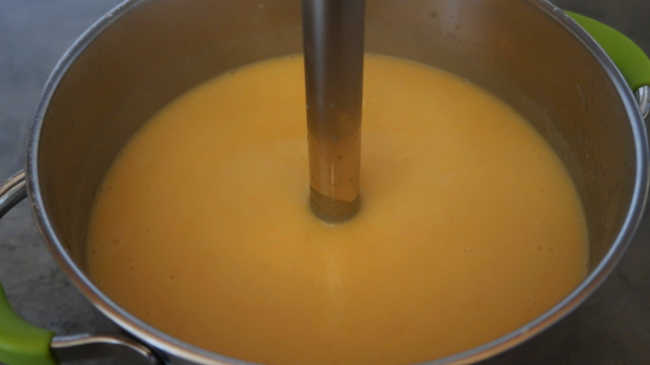 Blending ingredients to a creamy root vegetable soup recipe