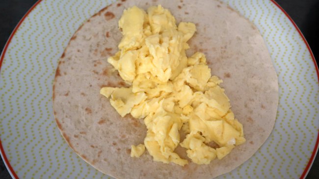 Burrito topped with scrambled eggs