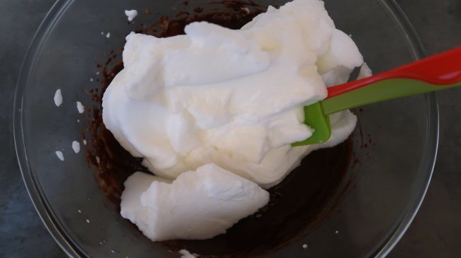 Folding whisked egg whites into melted chocolate mixture