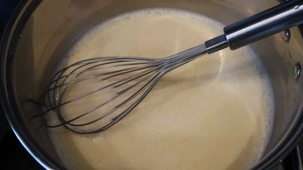 Whisking ingredients together over low heat in a saucepan